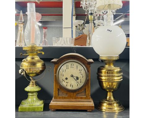 Two brass oil lamps, tallest 57cm, together with an oak mantle clock.