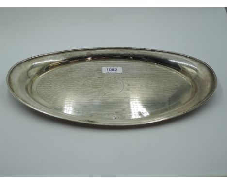 A silver tray of oval form having engine turned decoration and plain cartouche, Birmingham 1915, F H Adams Ltd,  approx 329.6