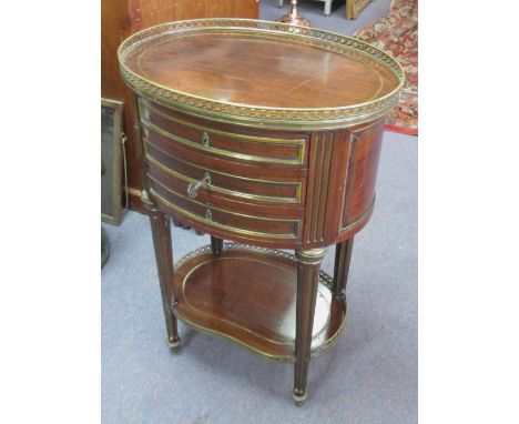 PETITE COMMODE, French 19th century mahogany and brass mounted with an oval top having a brass gallery and three small drawer