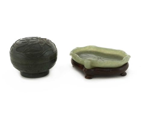 A Chinese jade brush lick,Qing dynasty (1644-1911), in the shape of a lotus leaf with a seedpod to the side, the stone of cel