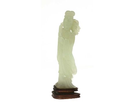 A Chinese jade figure, Qing dynasty (1644-1911), of a standing lady wearing a long robe, carrying a fruiting peach branch ove