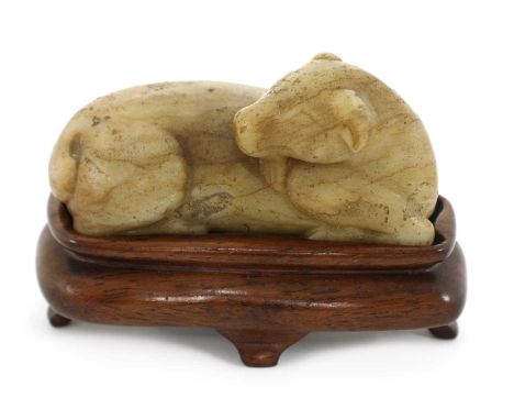 A Chinese jade carving,Qing dynasty (1644-1911), of a recumbent goat, the mottled stone with russet inclusions and streaks, 8