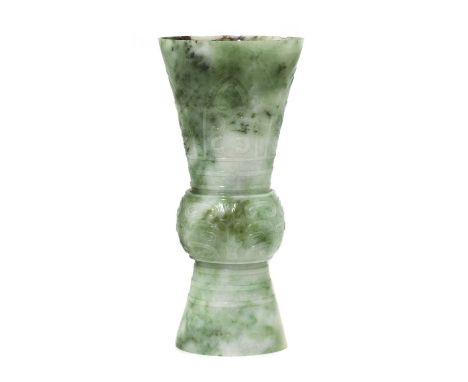 A Chinese jade gu vase,early 20th century, of typical compressed form, the bulging central section carved with a taotie mask,