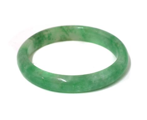 A jade bangle, of typical rounded form, inner diameter 5.5cmCondition report: Cracks to stone. A section about 4cm across wit