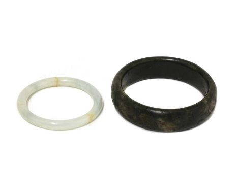 A Chinese spinach jade bangle, carved with mythical beasts against a diapered ground in shaped panels, 8.7cm diameter, and a 