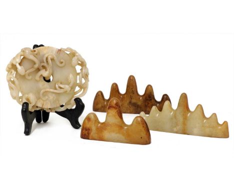 A collection of three Chinese jade brush rests, 20th century, carved in the form of mountain ranges, one with seven peaks, 14