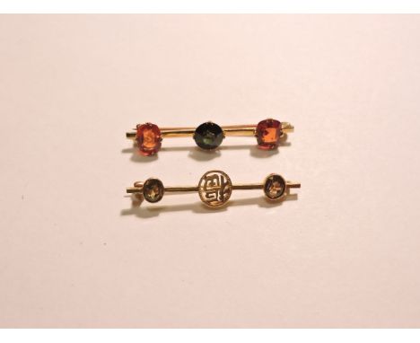 A three stone sapphire and garnet brooch, tested as approximately 14ct gold, ignore markings, with a 9ct gold pin and a gold 