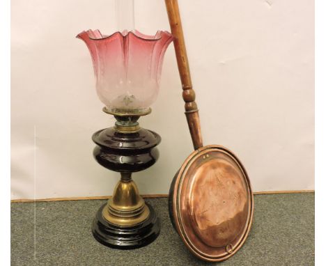 A Victorian oil lamp, with ruby glass reservoir, and cranberry shade, and a 19th century copper bed warmer