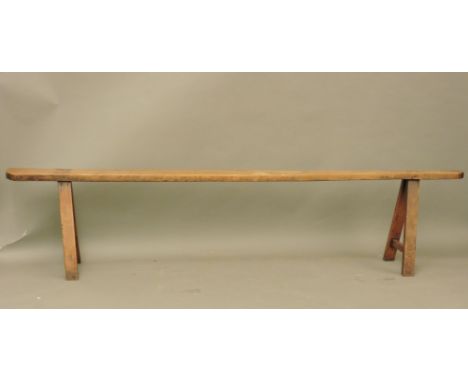 A country made fruitwood or sycamore bench, 234cm long