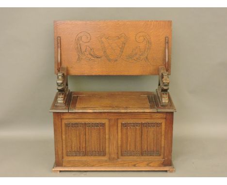 An oak monk's bench, with linen fold panelling and lion supports, 92 x 43 x 77cm high
