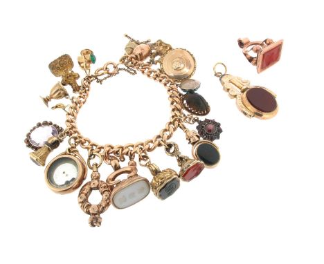 A gold charm bracelet, the curb-link bracelet set with seven seals, a gold locket (damaged), a gold compass (damaged) and var
