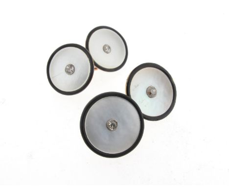 A pair of mother-of-pearl disc cufflinks, set with a central diamond and a border of black enamel in yellow gold, oval chain 