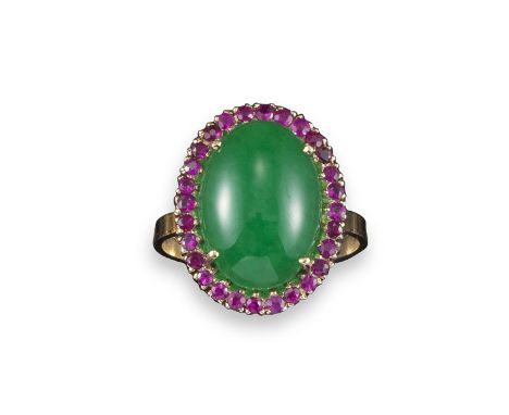 A jade and ruby cluster ring, the oval cabochon jade set within a surround of circular-cut rubies in yellow gold, size O