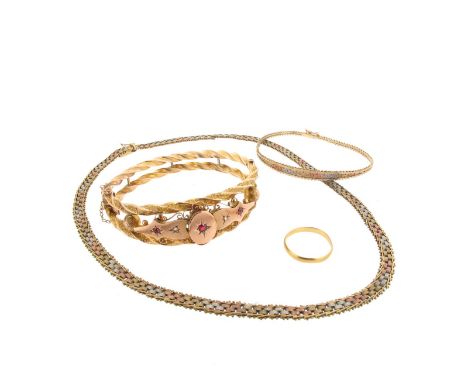 A late Victorian gold hinged bangle set with rubies and diamonds in twisted rope design, a plain gold wedding band, a three-c