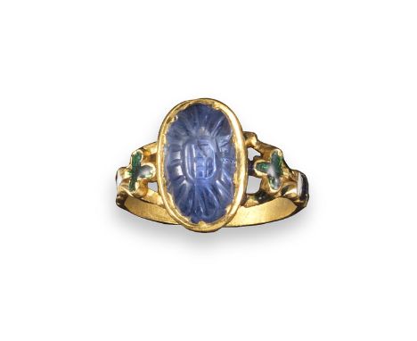 An Indian ring set with a sapphire, the carved oval-shaped sapphire pavé-set with enamel decoration to the mount, bifurcated 