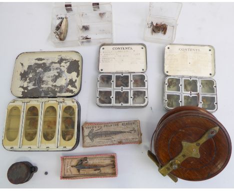 A vintage reel, three fly boxes, a boxed Brown's Phantom Minnow and split shot weights in a tin dispenser
