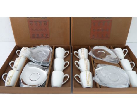 Two boxed sets of six coffee cups and saucers, the cups decorated with gilt dots and the saucers of teardrop form