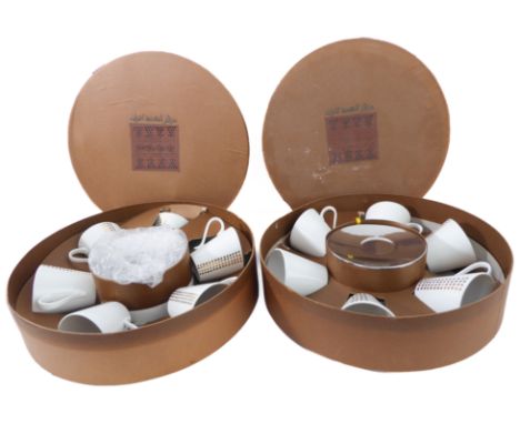 Two boxed sets of six cups and saucers, the cups decorated with gilt dots and the saucers of teardrop form