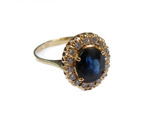 A sapphire and diamond-set cluster ring, the oval mixed-cut sapphire within a surround of brilliant-cut diamonds, to the plai