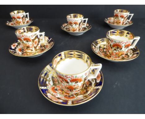 A set of six Derby coffee cans and saucers, each hand-decorated and gilded in the Imari palette and with red painted marks to