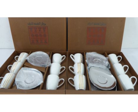 Two boxed sets of six coffee cups and saucers, the cups decorated with gilt dots and the saucers of teardrop form