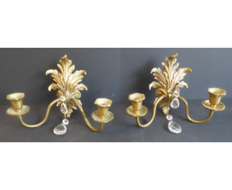 A pair of early 20th century cast brass two-light wall appliques with cut-glass droppers: the main bodies modelled as acanthu