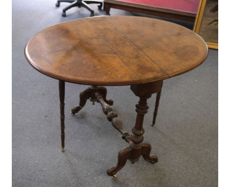 Sutherland Table. A Victorian walnut sutherland table, line inlaid with curved drop-flaps, on foliate carved supports with ce