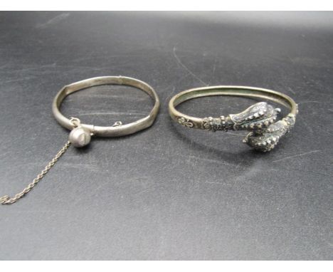 A silver bangle with charm and a white metal bangle&nbsp;