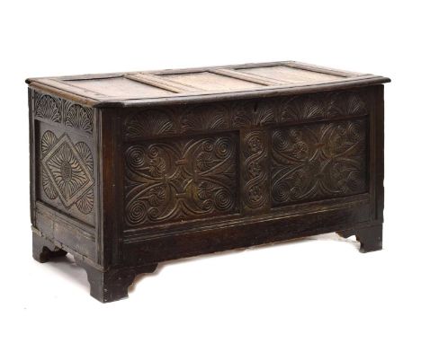 17th century oak coffer or bedding chest, with three-panel lid, the front with carved foliate arcaded frieze over two fielded