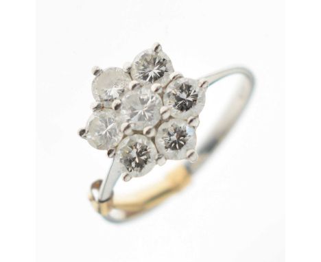 18ct white gold seven-stone diamond daisy cluster ring, size K½ approx (ring clip attached), London 1975, 2.4g gross approx