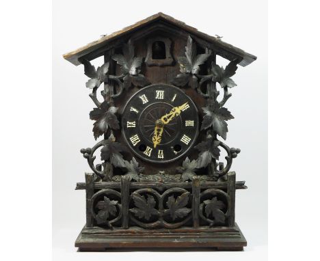 A late 19th/early 20th century Black Forest bracket cuckoo clock, the circular dial bearing roman numerals, eight day movemen