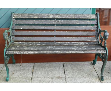 A garden bench having hardwood slats and heavy cast iron ends with scroll legs - 130cm wide together with a hardwood companio