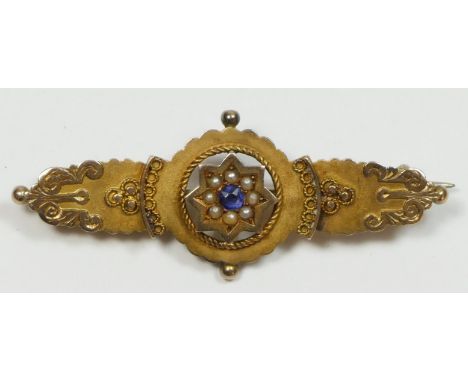 A Victorian 9ct gold panel brooch, set with a sapphire boarded by half pearls 