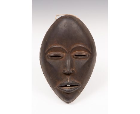   Ivory Coast, Dan mask, With black patina, the lips with blackened added surface. With remnants of old label on the inside. 