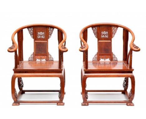   China, paar Huali houten horseshoe vormige fauteuils, 20ste eeuw, gedecoreerd met gestoken en opengewerkte florale patronen