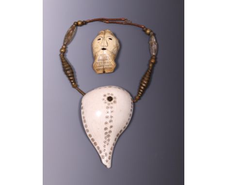   India, Naga, cut and decorated Turbinella shell on a chain with two quartz beads and Timor, a decorated skull of a small ma