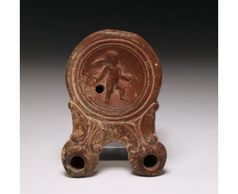   Roman terracotta oil lamp, 1st century, with a double snout and relief decor of Amor. Provenance: collected 1970s till earl
