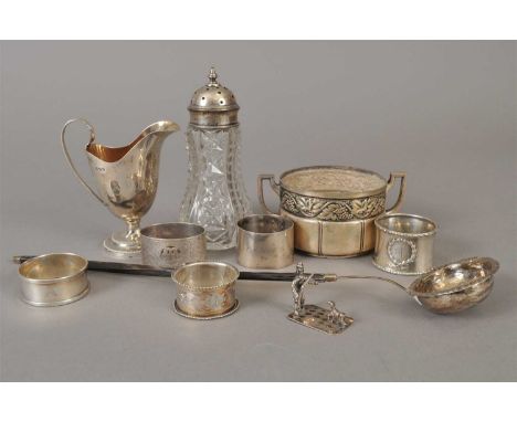 A silver helmet cream jug, London 1891, together with five silver napkin rings, a toddy ladle, a white metal two handled suga