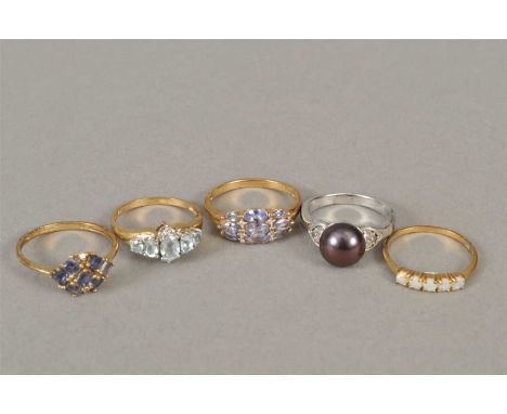 Two 9ct gold tanzanite rings, together with a 9ct gold aquamarine ring, a silver pearl ring and a 9ct gold opal ring