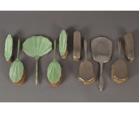 A four piece silver and green guilloche enamel dressing table set, Birmingham 1930 &amp; 1931, comprising; a hand mirror, two