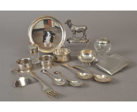 A small collection of silver, to include; a circular mounted photograph frame, an engine turned cigarette case, a tea straine