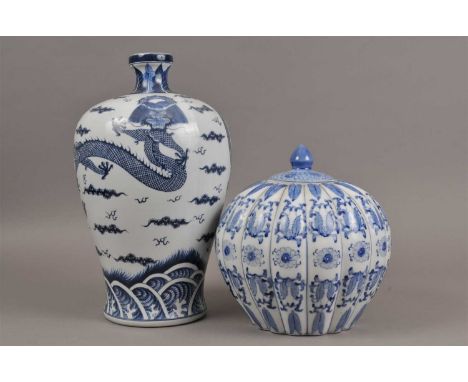 A tall reproduction Chinese blue and white ceramic vase, of baluster form, decorated with a dragon in flight, marked to under