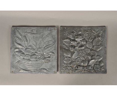 A decorative pair of moulded lead panels of square form, one decorated with a still life arrangement of a bowl laden with fru