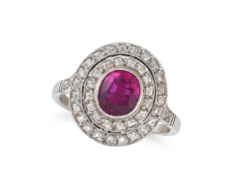 A RUBY AND DIAMOND CLUSTER RING in platinum, set with an oval cut ruby of approximately 1.20 carats in a double halo of Frenc