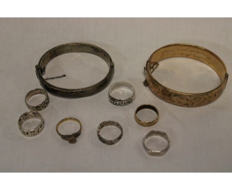 A silver oval bangle with engraved decoration, gold-plated bangle, selection of various silver rings, wedding band etc.