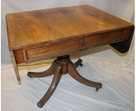 A 19th century rosewood drop leaf sofa table with two drawers in the frieze on turned column and scroll legs with casters