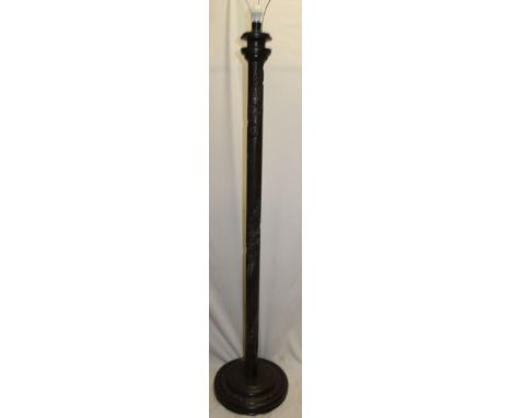 A Chinese carved teak standard lamp with figure and landscape decoration on circular base