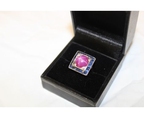 A platinum dress ring set a central star ruby surrounded by sapphires