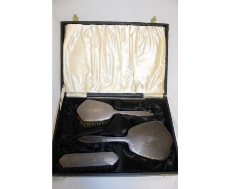 An EIIR silver four piece dressing set comprising hand mirror, hair brush, clothes brush and comb, Birmingham marks 1955 in s