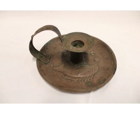 A Newlyn copper circular chamber candlestick by H Dyer with raised fish decoration, signed 7" diameter